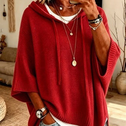 Torso view of the red hooded jumper with drawstrings and ribbed hem, layered over a white top with gold necklaces. 13