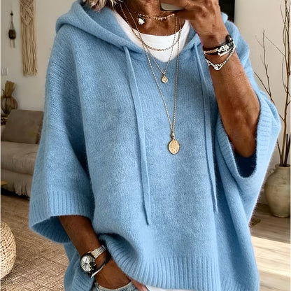 Torso view of the sky blue hooded jumper with a soft knit, drawstrings and ribbed cuffs, layered over a white top. 17