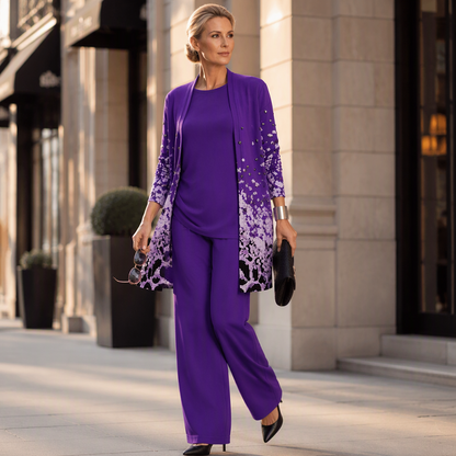 Model in the purple set walking along a city street, holding sunglasses and a black clutch, wearing black pointed heels. 12