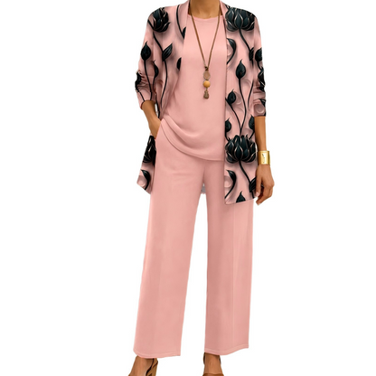 Model wearing the pink set with black lotus-print open cardigan, matching plain top and wide-leg trousers, finished with a gold cuff. 2