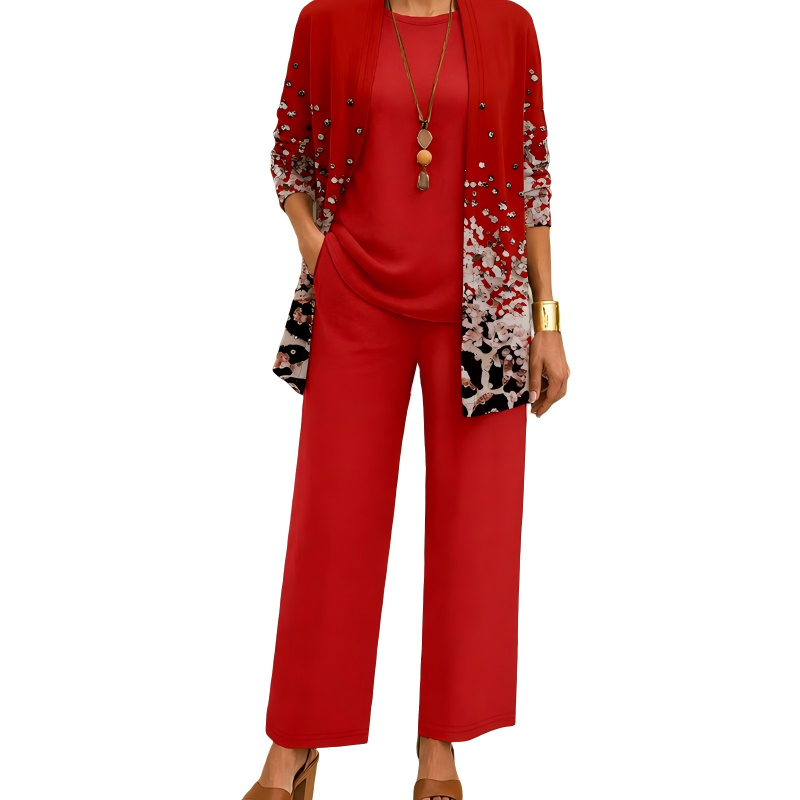 Model wearing the red set, the open cardigan fading into a speckled print at the hem, with matching top and wide-leg trousers. 5