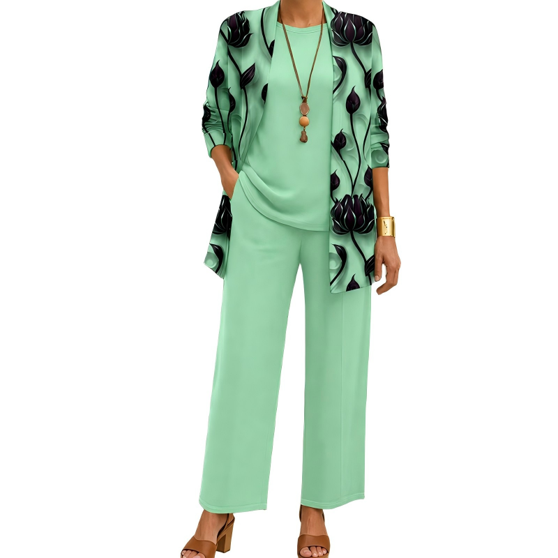 Model wearing the mint green set with dark lotus-print open cardigan, plain top and wide-leg trousers, with a long beaded pendant necklace. 6