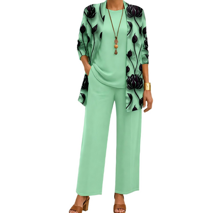 Model wearing the mint green set with dark lotus-print open cardigan, plain top and wide-leg trousers, with a long beaded pendant necklace. 6