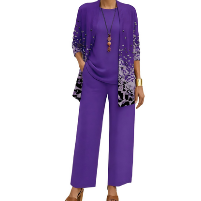 Model wearing the purple set, the open cardigan showing a speckled print that deepens towards the hem, with matching top and trousers. 7