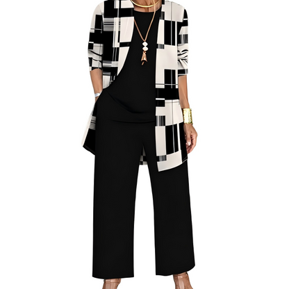 Model wearing the black and cream set, the open cardigan in a geometric block and stripe print over a plain black top and trousers. 8