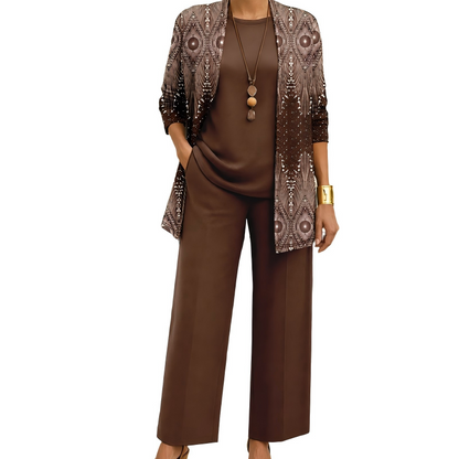 Model wearing the brown set, the open cardigan in a shimmering ornate diamond pattern, over a plain round-neck top and wide-leg trousers. 10