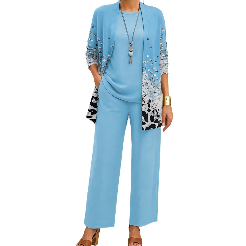 Model wearing the light blue set, the open cardigan with a scattered silvery speckle print fading into black and white at the hem. 11
