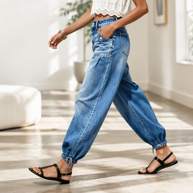 Side view of a model walking indoors in the jeans, one hand in the pocket, hem tie visible 7