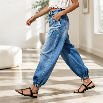 Side view of a model walking indoors in the jeans, one hand in the pocket, hem tie visible 7