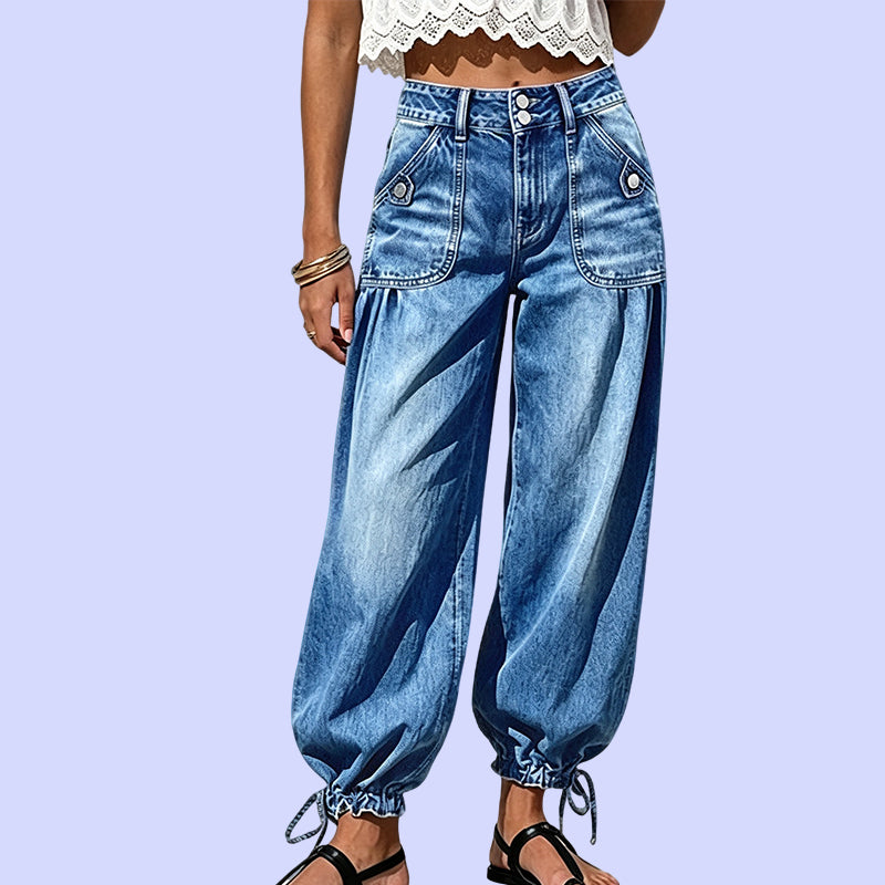 Close front view of the blue jeans from the waist down, showing flap pockets and drawstring hems 10