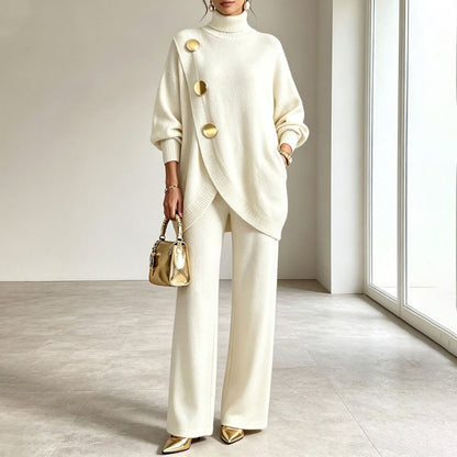 Model wearing the cream knit set with gold buttons, carrying a small gold handbag 2