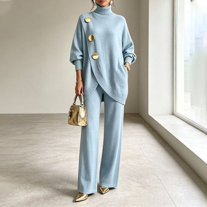 Model in the pale blue knit set, hand in pocket, holding a gold handbag 1
