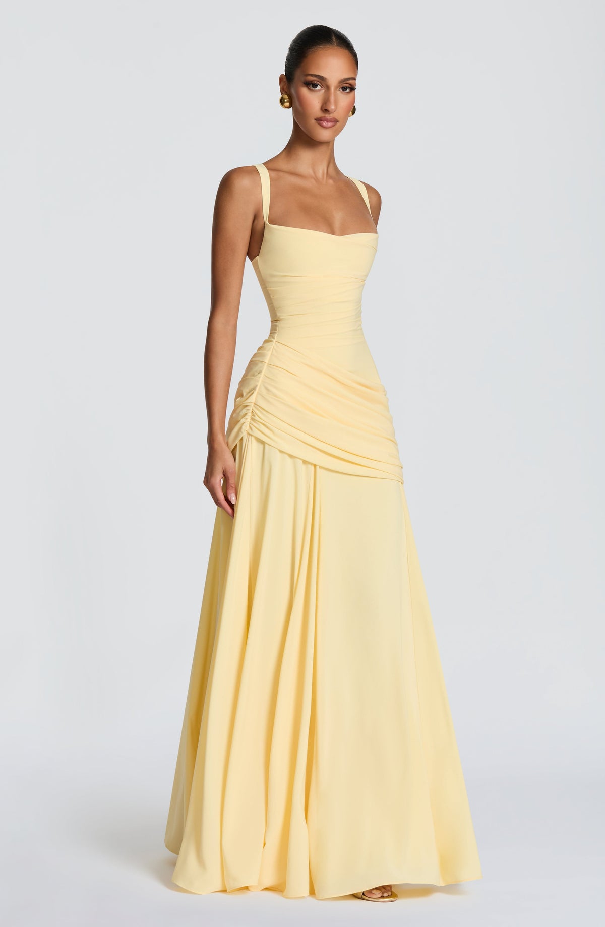 Three-quarter side view of the pale yellow dress, showing the ruched side seam, wide straps and full floor-length skirt. 3