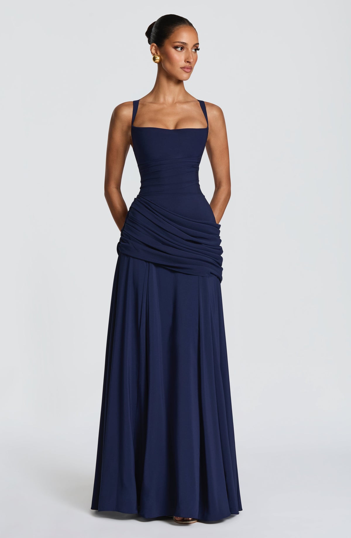 Navy dress full length, front view, with hands in the side pockets and a floor-skimming skirt 8