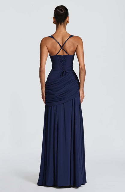 Back view of the navy dress showing the corset-style lace-up back, crossed adjustable straps and the draped panel at the hip. 11