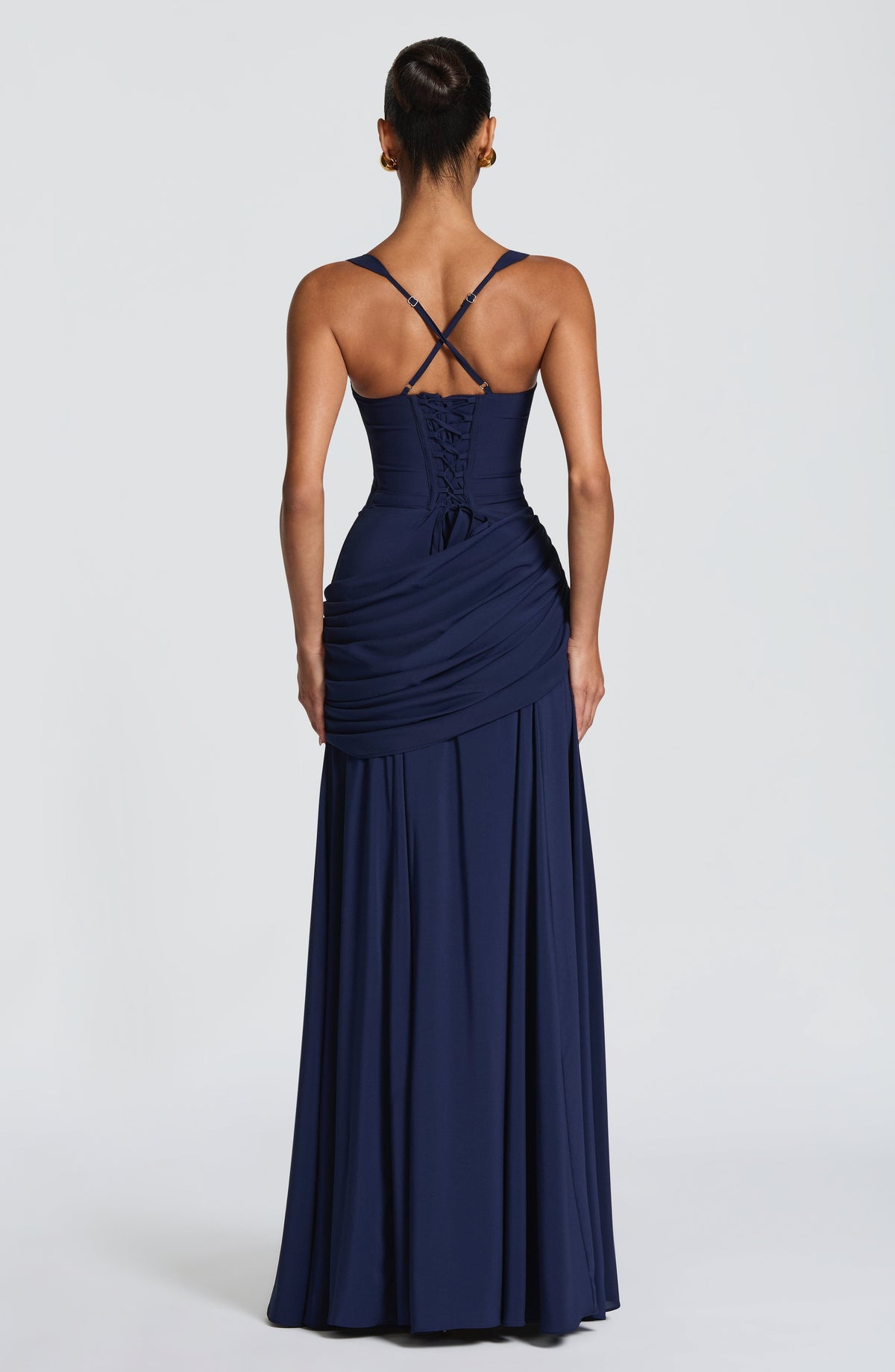 Back of the navy dress showing crossed thin straps, lace-up corset back and draped hip panel 9