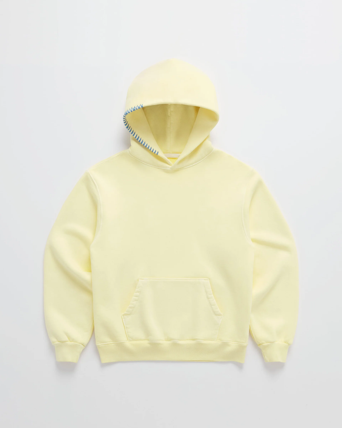 Flat lay of the pale yellow hoodie with blue contrast stitching along the hood edge and a kangaroo pocket 1
