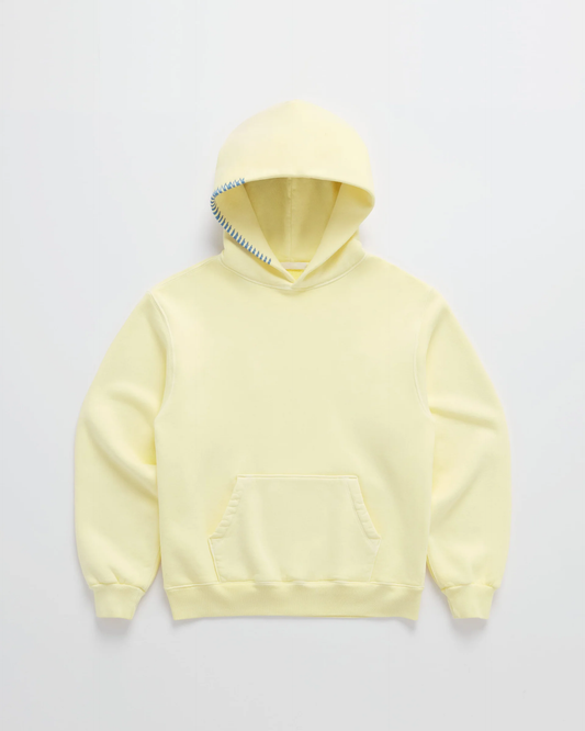 Flat lay of the pale yellow hoodie with blue contrast stitching along the hood edge and a kangaroo pocket 1