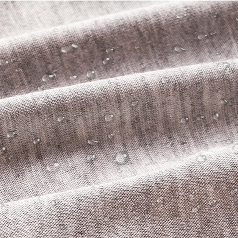 Close-up of grey knitted fabric folds with small water droplets beading on the surface. 9