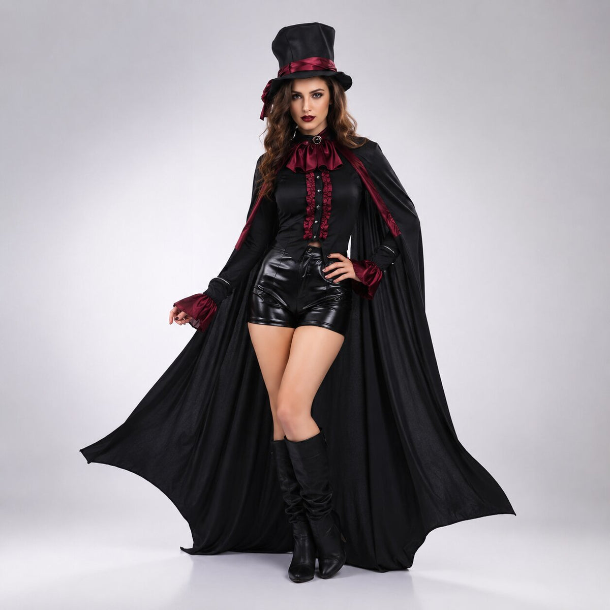 Woman in a black top hat, red satin cravat and frilled blouse, with a long black cape, shiny shorts and knee boots. 5