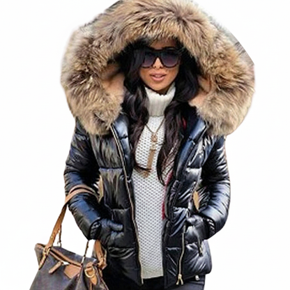 Cut-out of a model in the black quilted jacket with brown fur hood, sunglasses and a brown handbag on her arm. 8