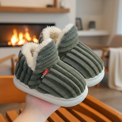 Pair of green ribbed fleece-lined slippers held up in front of a lit fireplace. 6