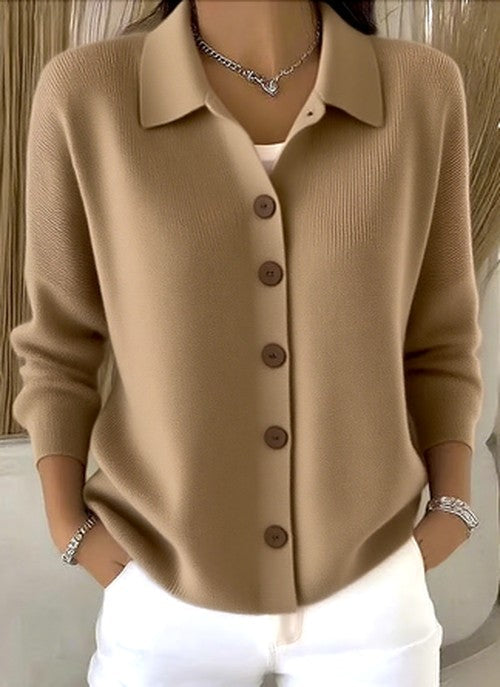 Model wearing the camel-beige version of the knit cardigan, front buttoned, with silver bracelets and a chain necklace. 3
