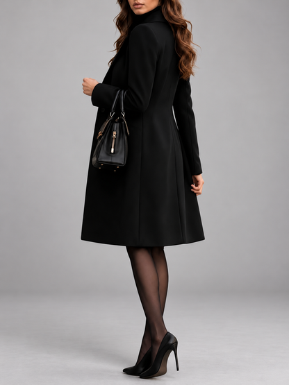 Side-back view of the black coat showing its panelled seams and flared hem, worn with heels 2