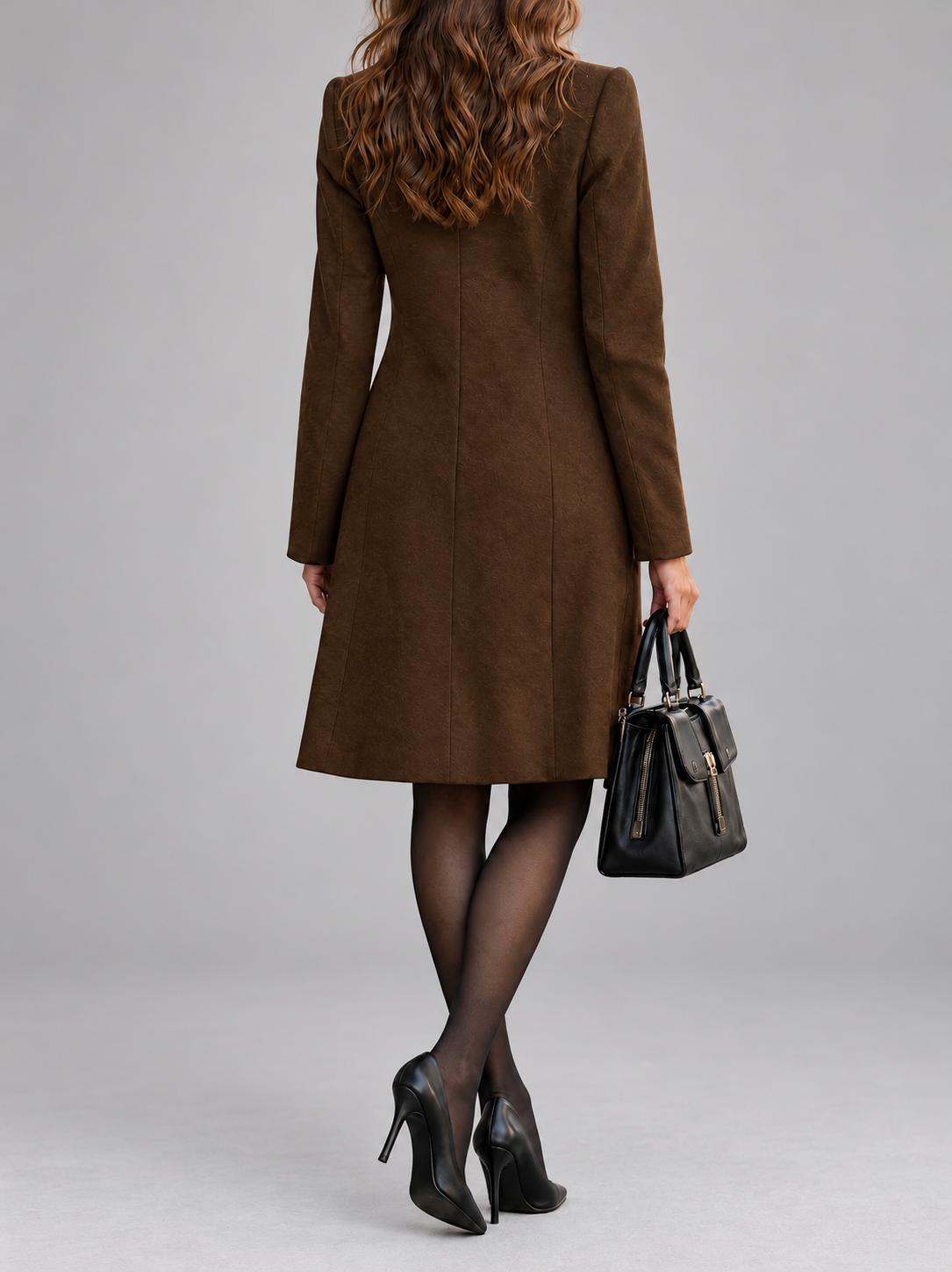 Back view of the brown coat showing vertical seams and a flared skirt, with black heels 7