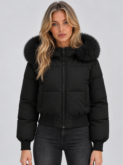 Front view of the black cropped puffer jacket, zipped up, worn by a model with black jeans 1