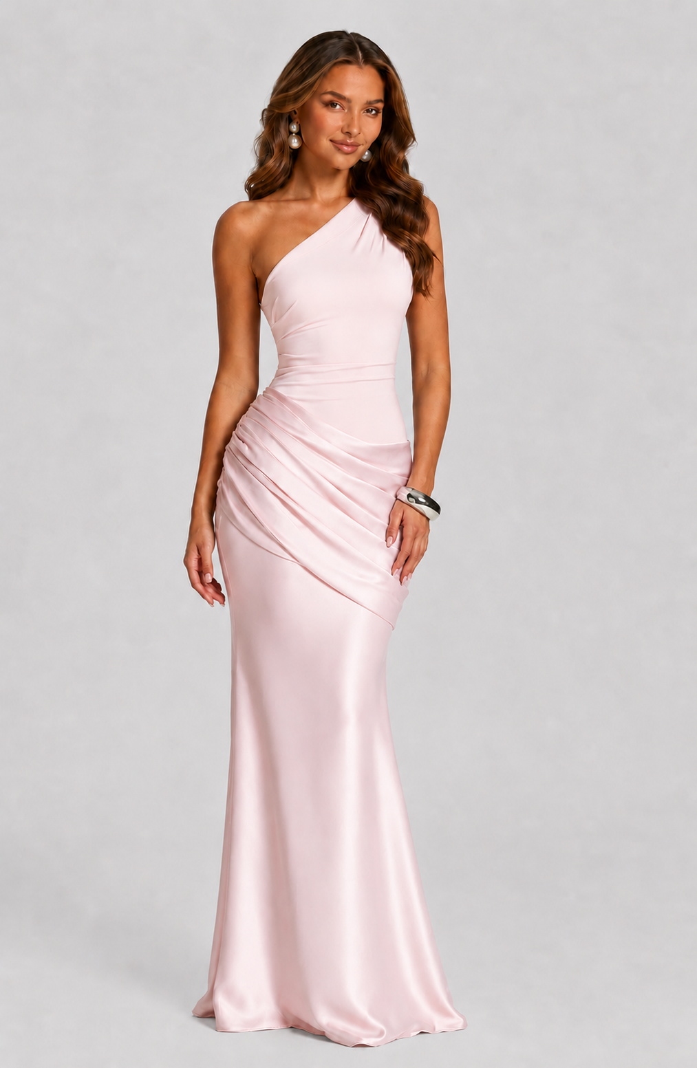 Pale pink version worn by a model with pearl earrings and a silver cuff, front view of the draped satin. 12